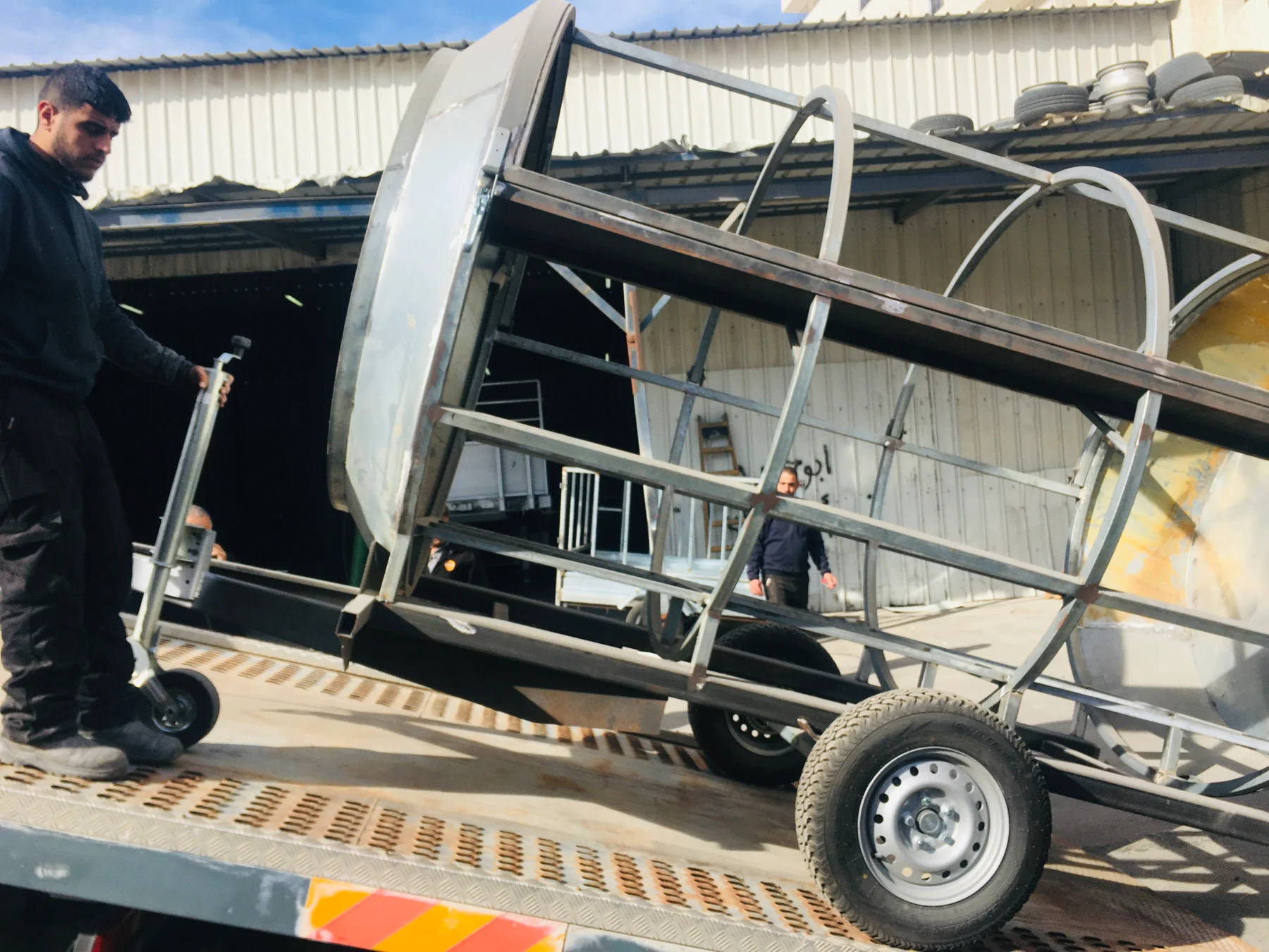 A metal circular framework being positioned on a vehicle.